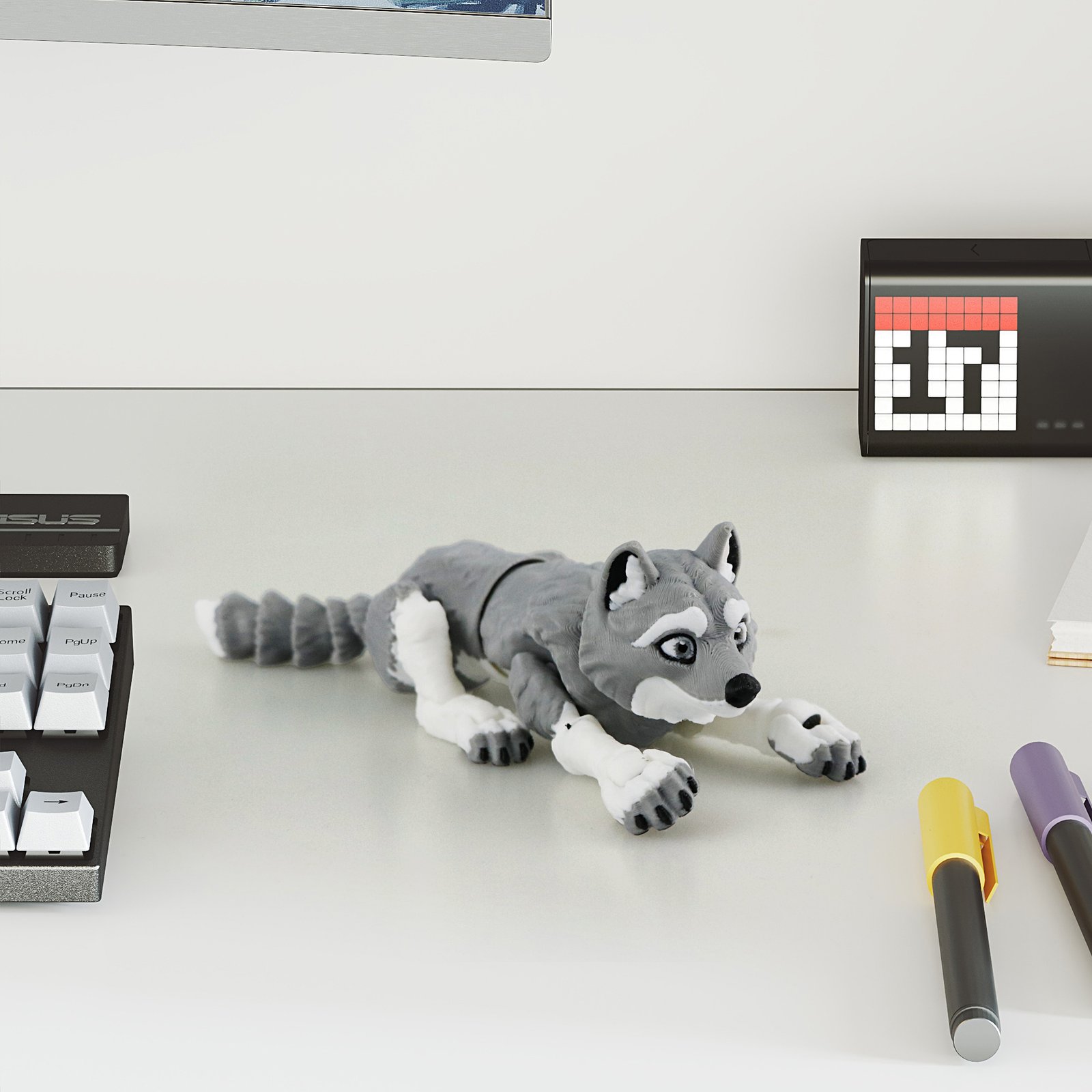 Small gray articulated husky 3D printed toy on a desk